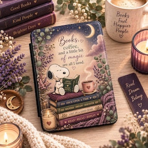 May include: A rectangular e-reader case featuring a Snoopy illustration reading a book atop a stack of books. The text reads: Books, coffee, and a little bit of magic are all I need. The design includes lavender, a crescent moon, and a coffee cup.