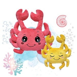 Pode incluir: Dois caranguejos de pelúcia, um rosa e outro amarelo, com rostos sorridentes e olhos grandes. Os caranguejos estão sentados em um fundo branco com um design de aquarela azul e branco.
