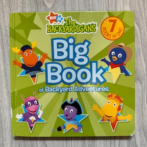 May include: A green hardcover book titled The Backyardigans Big Book of Backyard Adventures, featuring the Nick Jr. logo and a 7 Books in One badge. The cover displays five cartoon characters in blue star frames against a light green sunburst.