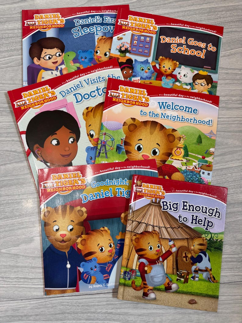 K&ouml;nnte beinhalten: Eine Sammlung von Kinderb&uuml;chern mit der Figur Daniel Tiger. Zu den Titeln geh&ouml;ren "Daniel's First Sleepover", "Daniel Goes to School", "Daniel Visits the Doctor" und "Welcome to the Neighborhood!". Die B&uuml;cher haben rote Einb&auml;nde.