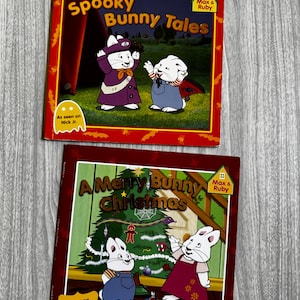 May include: Two Max & Ruby children's books. The top book is titled Spooky Bunny Tales, featuring two white bunnies in costumes. The bottom book is titled A Merry Bunny Christmas, featuring two white bunnies in front of a decorated Christmas tree.