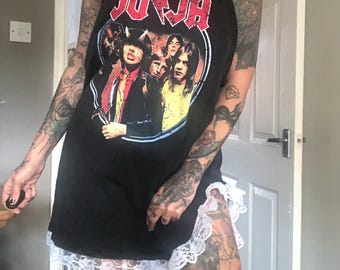 May include: A black sleeveless shirt with a white lace trim. The shirt features a vintage print of a rock band with the word "AC/DC" in red letters.