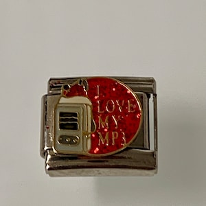 May include: A silver-toned charm with a red glitter accent. The charm features a white and gold illustration of a music player and the text "I LOVE MY MP3".