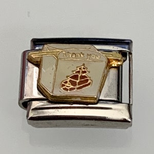 Peut inclure: Un maillon de bracelet modulaire en acier inoxydable rectangulaire avec un motif émaillé blanc et doré représentant une boîte à emporter. Le texte Thank you est inscrit sur le devant avec un petit motif rouge en forme de pagode.