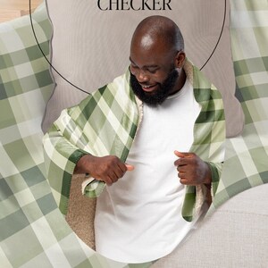 May include: A person is wrapped in a green and white plaid sherpa blanket. The blanket has the text "CLASSIC SWISS CHECKER" and "NEW SHERPA BLANKET COLLECTION" on it.