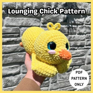 May include: A yellow crocheted chick plush toy with large blue eyes, a small orange beak, and pink cheeks. The text Lounging Chick Pattern is at the top, and a white circle with the text PDF PATTERN ONLY is in the bottom right corner.