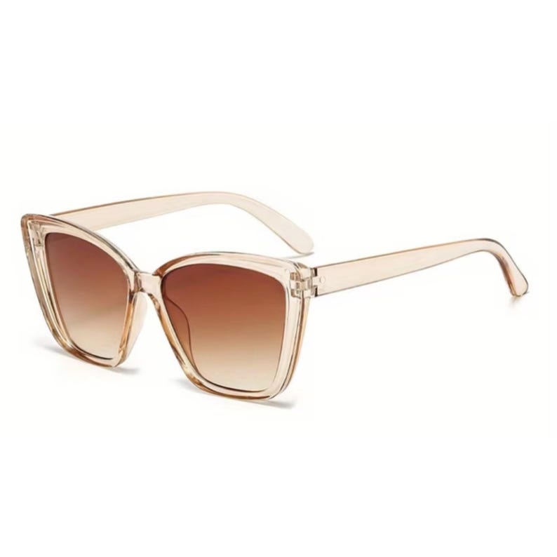 Pu&ograve; includere: Occhiali da sole a occhi di gatto con montatura marrone chiaro traslucida e lenti sfumate marroni. Gli occhiali da sole hanno una forma classica con un design leggermente oversize. Le aste sono di colore marrone chiaro abbinato.