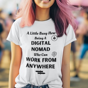 May include: White t-shirt with black text that reads "A Little Busy Now Being A Digital Nomad Who Can Work From Anywhere" with a laptop and globe icon.