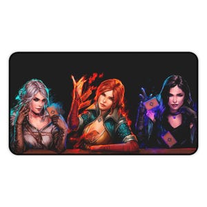 May include: A rectangular mousepad featuring three women from The Witcher series. Each woman is holding playing cards. The women have white, red, and black hair. The background is black.