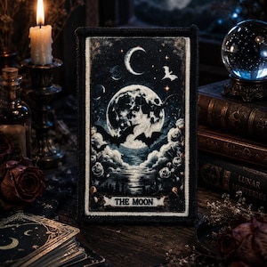 May include: A rectangular embroidered patch featuring a dark night scene with a large full moon, silhouettes of flying bats, and clouds over a body of water. The text THE MOON is printed in a banner at the bottom of the black-bordered design.
