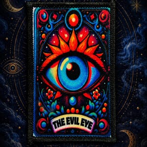 May include: A rectangular embroidered patch featuring a vibrant central blue eye surrounded by red and orange sunburst rays, floral accents, and a banner at the bottom with the text THE EVIL EYE in black capital letters on a white background.