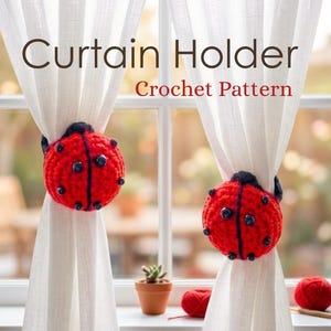 Two sheer white curtain panels gathered with matching red and black crochet ladybug tie-backs in front of a white framed window.