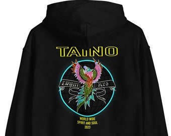 Op de afbeelding: Zwart hoodie met een geel "TAINO" logo en een kleurrijke phoenix-afbeelding met de woorden "ESPIRITU" en "ALMA" op een blauwe cirkel. De tekst "WORLD WIDE SPIRIT AND SOUL 2023" staat onder de afbeelding.