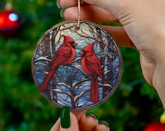 May include: Round Christmas bauble featuring a stained glass design of two red robins perched on a branch in a snowy winter scene.
