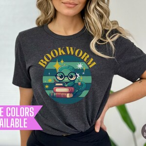 May include: Dark grey t-shirt with a graphic of a green worm wearing glasses and sitting on a stack of books. The text "BOOKWORM" is in a yellow circle around the worm.