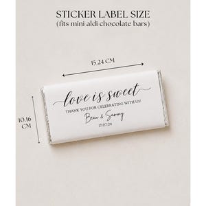 May include: A white rectangular sticker label for mini chocolate bars measuring 6 inches by 4 inches. The label features black text reading love is sweet, THANK YOU FOR CELEBRATING WITH US!, Beau & Sammy, and the date 17.07.24 in a script font.