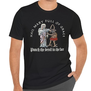 Puede incluir: Una taza de cerámica blanca con un asa negra y el texto "But First, Coffee" en un estilo manuscrito. La taza está sobre una superficie blanca. La taza mide aproximadamente 10 cm de alto.