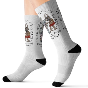 May include: White socks with a black heel and toe. The socks feature a graphic of a man punching a devil in the face with the text "Full of Grace, Hail Mar, Punch the Devil in the Face".