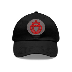 Peut inclure: Casquette de baseball noire avec un patch brodé gris et rouge représentant deux cœurs entrelacés surmontés d'une couronne.