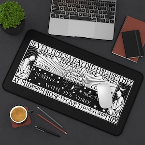 May include: Black rectangular mousepad featuring a detailed black and white design with text and illustrations of robed figures. The text reads "SEVEN TIMES A DAY DID I PRAISE THEE". A laptop, coffee cup, and pens are also visible.