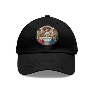 Peut inclure: Casquette de baseball noire avec un patch circulaire représentant une peinture de Jésus et ses disciples lors de la Cène. Le patch a une bordure cousue.
