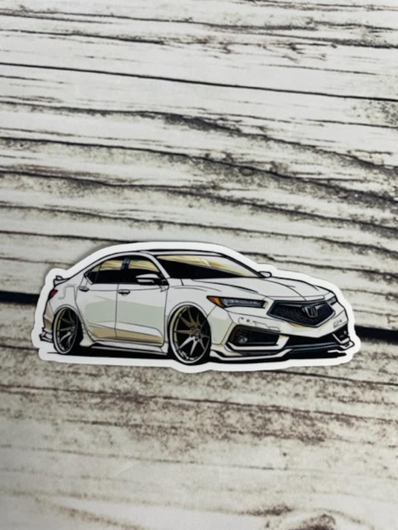 May include: A white car sticker featuring a detailed illustration of a white saloon car with black accents and gold wheels. The car has a black front grille with a silver emblem.