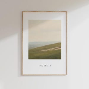 May include: Framed landscape art print featuring a serene hillside scene with green grass and a distant horizon under a soft, cloudy sky. The print is in a wooden frame and includes the text "THE TRUTH" at the bottom.