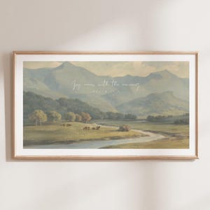 May include: A framed print with a landscape scene of a river winding through a valley with mountains in the background. The print features the text "Joy comes with the morning" and "Psalm 30".
