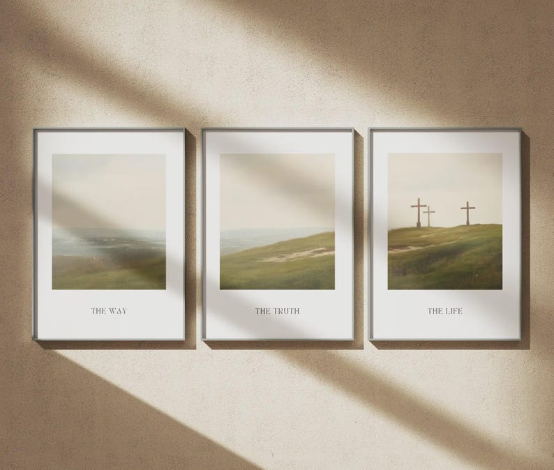 May include: Three framed art prints with landscape scenes. The prints are in silver frames and feature soft, muted colors. The first print says "THE WAY", the second says "THE TRUTH", and the third says "THE LIFE". The art prints are displayed on a beige wall.
