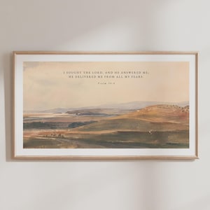 Può includere: Una stampa incorniciata con un paesaggio di colline ondulate in tonalità tenui. Il testo "I SOUGHT THE LORD, AND HE ANSWERED ME, HE DELIVERED ME FROM ALL MY FEARS. Salmo 34:4" è stampato in alto.
