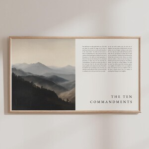 May include: Framed art print featuring a landscape of misty mountains on the left and text on the right. The text reads "THE TEN COMMANDMENTS" in a serif font. The mountains are a gradient of dark to light gray.