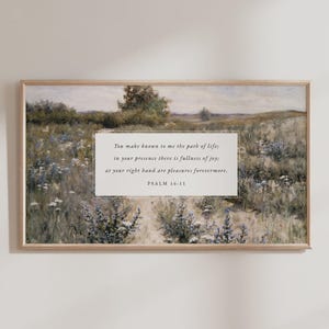 Puede incluir: Lámina artística enmarcada que representa un campo de flores silvestres en tonos suaves. La obra de arte incluye el texto "You make known to me the path of life; in your presence there is fullness of joy; at your right hand are pleasures forevermore. PSALM 16:11."