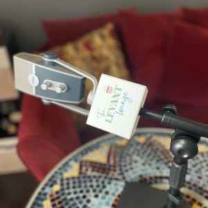 May include: A black microphone stand with a gray microphone attached. The microphone is labeled "The Levant Lounge".