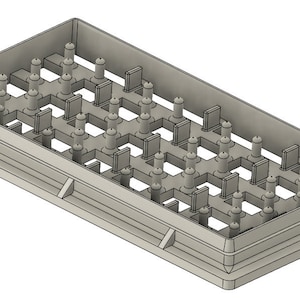 May include: A gray plastic mold with a grid of raised cylinders and rectangular blocks. The mold is designed for creating multiple identical objects.