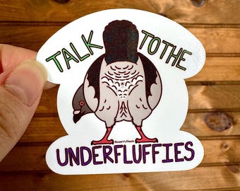 May include: A white sticker with a cartoon pigeon with the text "Talk to the Underfluffies" in green and purple lettering.