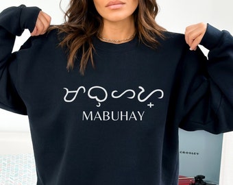 May include: Black crew neck sweatshirt with white text in a stylized script above the word "MABUHAY". The word "BLACK" is in a turquoise box in the lower left corner. The sweatshirt is a casual style.