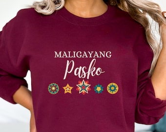 May include: Maroon sweatshirt with the text "Maligayang Pasko" in white lettering. The sweatshirt features five colourful star-shaped ornaments.