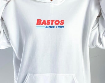 May include: White hooded sweatshirt with the text "Bastos Since 1989" in red and blue lettering.