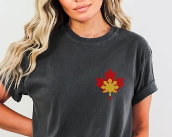 Peut inclure: Un t-shirt gris anthracite avec un motif de feuille d'érable rouge. La feuille d'érable est remplie des couleurs du drapeau philippin, jaune et rouge.
