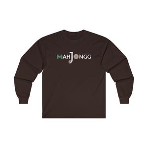 May include: A dark brown long-sleeved t-shirt with the text "MAH JONGG" printed in white on the front. The text is styled with a green and blue design.