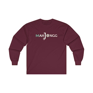 May include: A maroon long-sleeved t-shirt with the text "MAH JONGG" in white with a green and blue design.