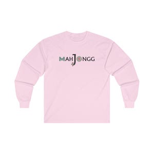 May include: A pink long-sleeved t-shirt with the text "MAH JONGG" in black letters and a colourful mahjong tile graphic.