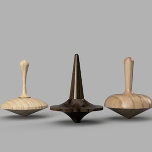 Puede incluir: Tres peonzas de madera, una marrón oscuro, una marrón claro y una marrón claro con la parte superior marrón oscuro.