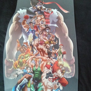 May include: A colorful graphic featuring multiple characters from the Street Fighter video game series. The image showcases various fighters in dynamic poses, with a prominent figure in the background. The artwork is vibrant and detailed.