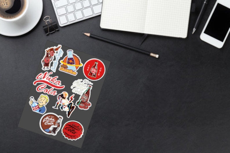 May include: A sheet of stickers featuring various designs from the Fallout video game series. The stickers feature the Nuka-Cola logo, a bottle of Nuka-Cola, and other characters and objects from the game.