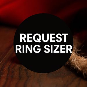 May include: A black circular graphic with the white text "REQUEST RING SIZER". The graphic is set against a dark wooden surface with a brown rope and a red background.