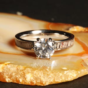 May include: A silver ring with a large, clear diamond set in the center. The band is made of antler and has a polished finish.