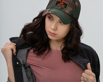 Puede incluir: Una gorra de béisbol con estampado de camuflaje y un parche rectangular negro en la parte frontal con el texto naranja FUCK AROUND AND FIND OUT. La gorra cuenta con una visera curva y una estructura clásica de seis paneles con un botón superior.