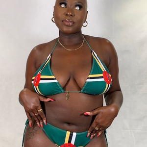 Puede incluir: Conjunto de bikini verde con la bandera de Dominica. La parte superior triangular y la parte inferior de cintura baja tienen una base verde oscuro con rayas amarillas, negras y blancas. El bikini tiene un círculo rojo con un loro en el centro. El bikini está hecho de tela suave y brillante.