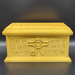 May include: A golden treasure chest with intricate carvings and the Eye of Horus symbol on the front.